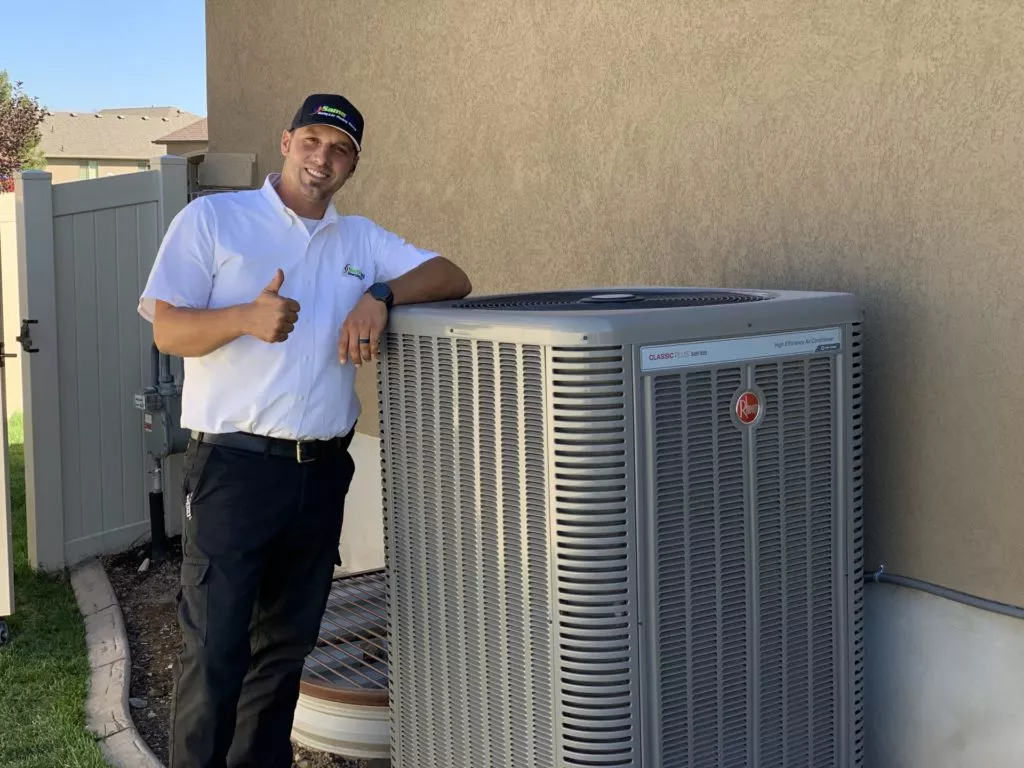 technician giving a thumbs up next to air conditioner
