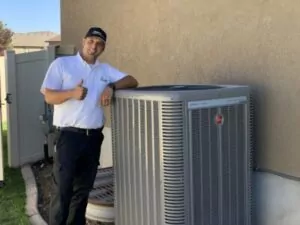 HVAC technician giving a thumbs up standing next to an outdoor AC unit