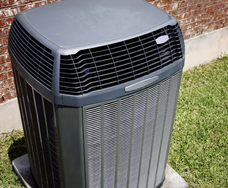 Outdoor AC unit sitting on the outside of a brick building